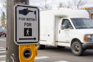 A close up of a cross walk signal button.