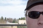 An extreme close up of a man wearing sunglasses and a hat.
