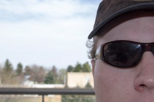 An extreme close up of a man wearing sunglasses and a hat.