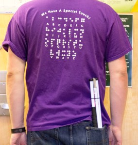the back of a shirt displays the Braille alphabet.